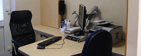 Modernes Büro mit Schreibtisch, Computer, Drucker und ergonomischen Bürostühlen.